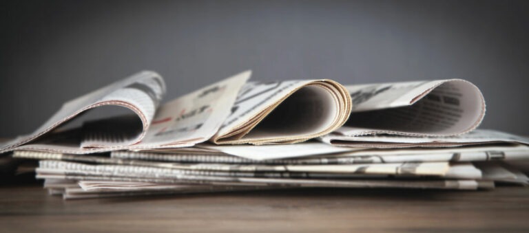 Newspapers On The Wooden Table